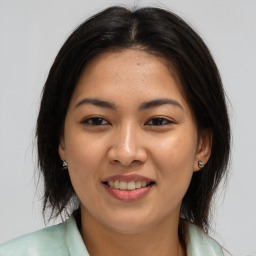 Joyful asian young-adult female with long  brown hair and brown eyes