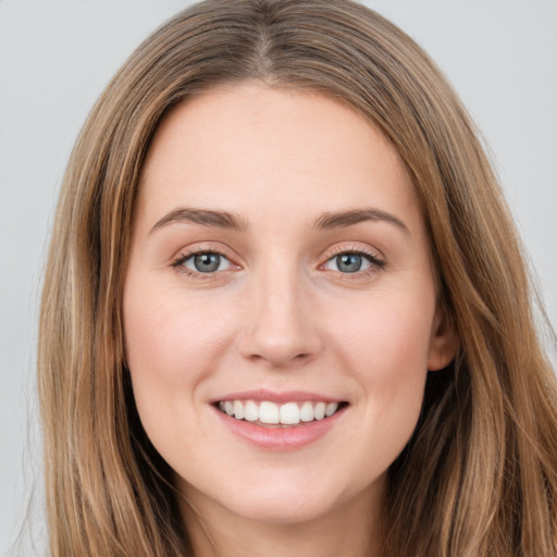 Joyful white young-adult female with long  brown hair and green eyes