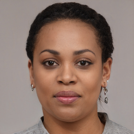 Joyful black young-adult female with short  black hair and brown eyes