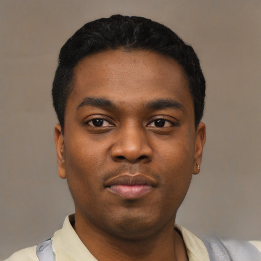 Joyful black young-adult male with short  black hair and brown eyes
