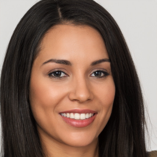 Joyful latino young-adult female with long  brown hair and brown eyes