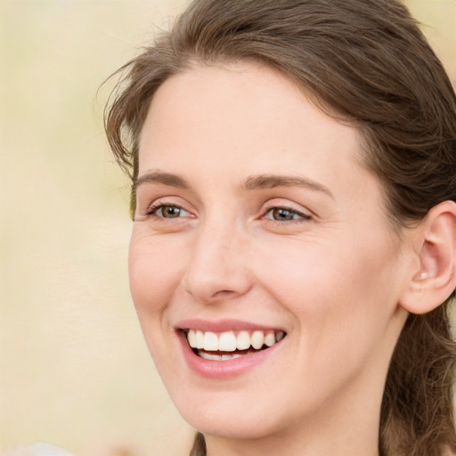 Joyful white young-adult female with long  brown hair and green eyes