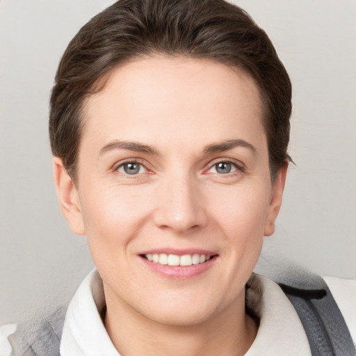 Joyful white young-adult female with short  brown hair and grey eyes