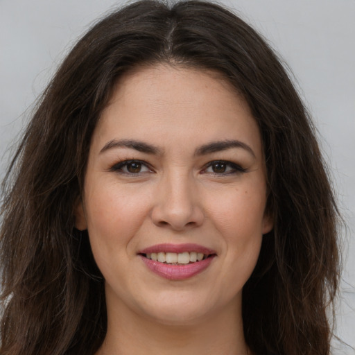 Joyful white young-adult female with long  brown hair and brown eyes