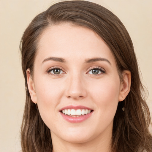 Joyful white young-adult female with long  brown hair and green eyes