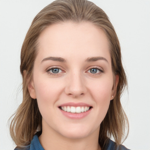 Joyful white young-adult female with long  brown hair and blue eyes