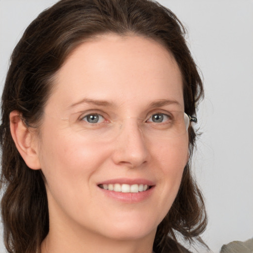 Joyful white young-adult female with medium  brown hair and grey eyes