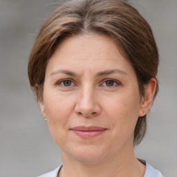 Joyful white adult female with medium  brown hair and grey eyes