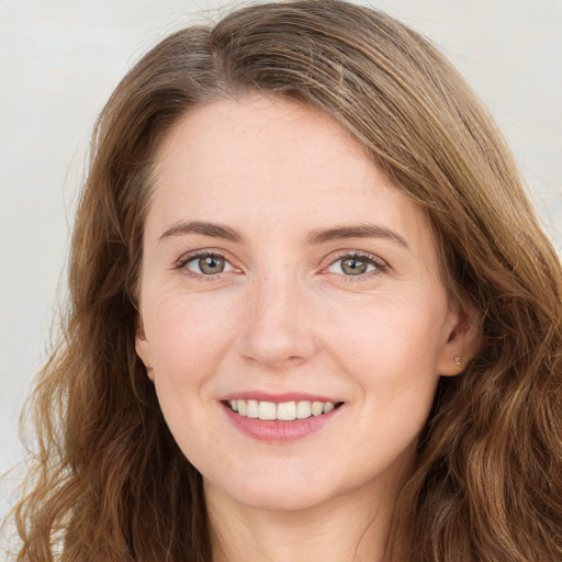 Joyful white young-adult female with long  brown hair and green eyes