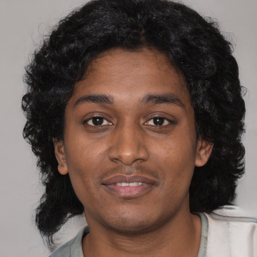 Joyful black young-adult female with long  black hair and brown eyes