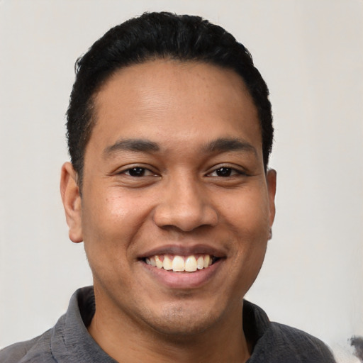 Joyful latino young-adult male with short  black hair and brown eyes