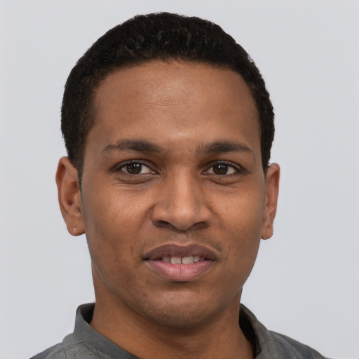 Joyful black young-adult male with short  black hair and brown eyes