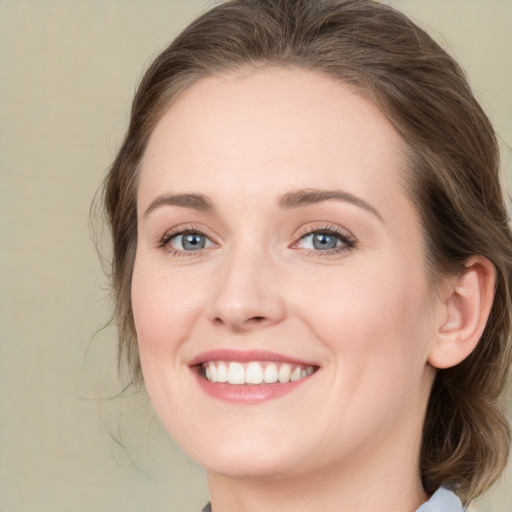 Joyful white young-adult female with medium  brown hair and green eyes