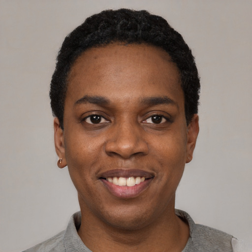 Joyful black young-adult female with short  black hair and brown eyes