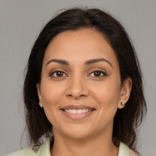 Joyful latino young-adult female with medium  brown hair and brown eyes