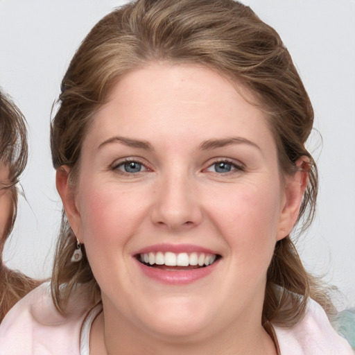 Joyful white young-adult female with medium  brown hair and blue eyes