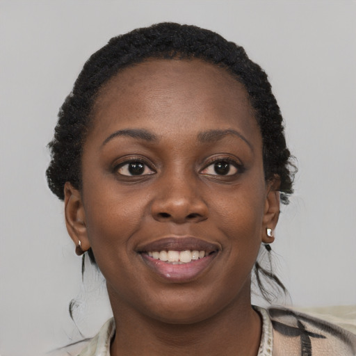Joyful black young-adult female with short  brown hair and brown eyes