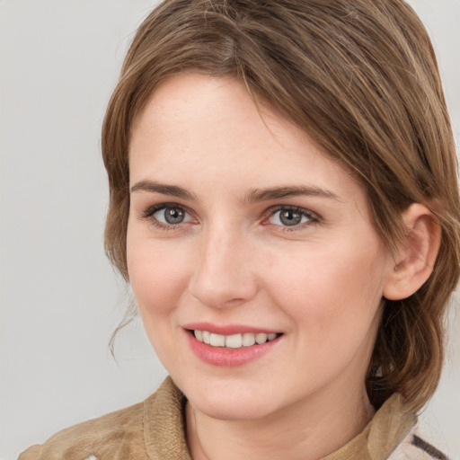 Joyful white young-adult female with medium  brown hair and grey eyes