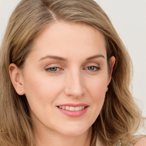 Joyful white young-adult female with long  brown hair and blue eyes