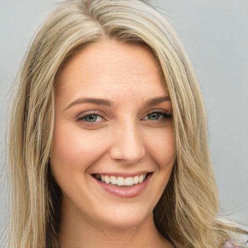 Joyful white young-adult female with long  brown hair and green eyes