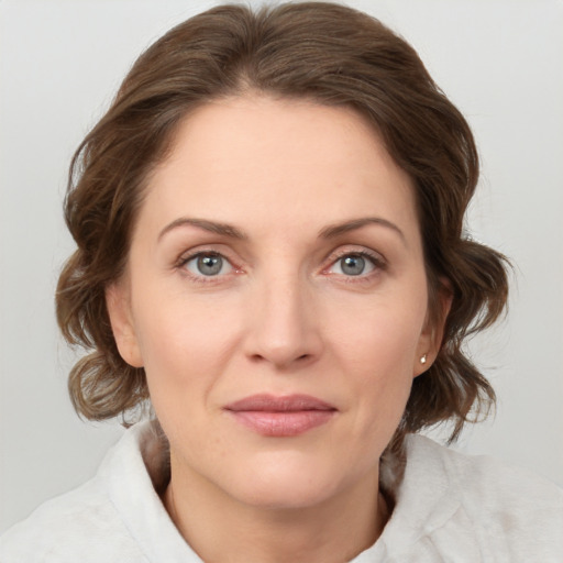 Joyful white young-adult female with medium  brown hair and grey eyes