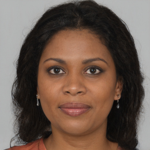 Joyful black young-adult female with long  brown hair and brown eyes