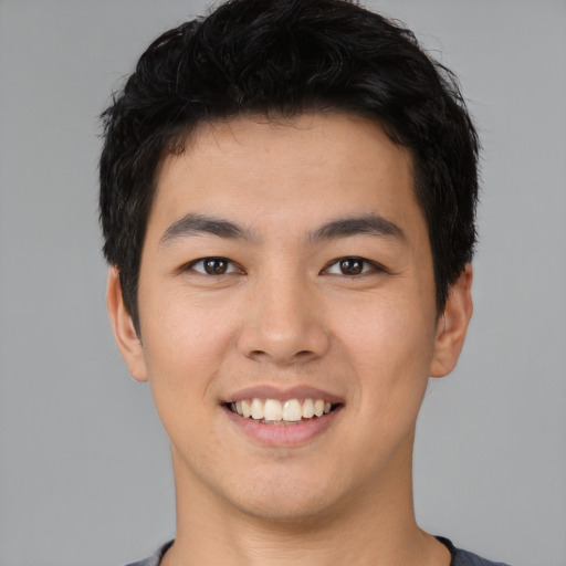 Joyful asian young-adult male with short  black hair and brown eyes