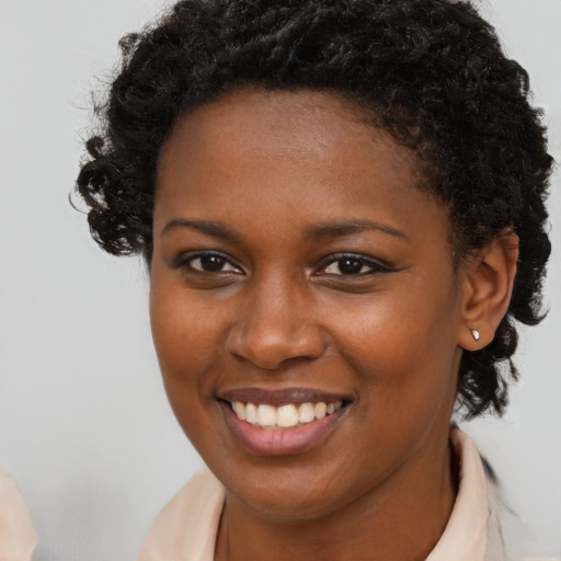 Joyful black young-adult female with short  brown hair and brown eyes
