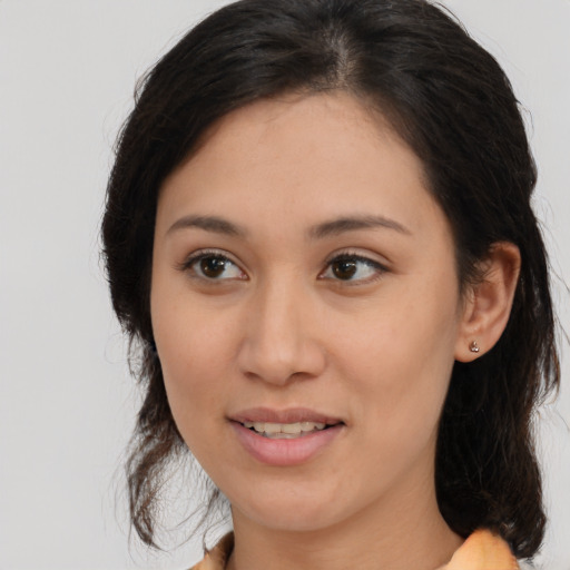 Joyful latino young-adult female with medium  brown hair and brown eyes