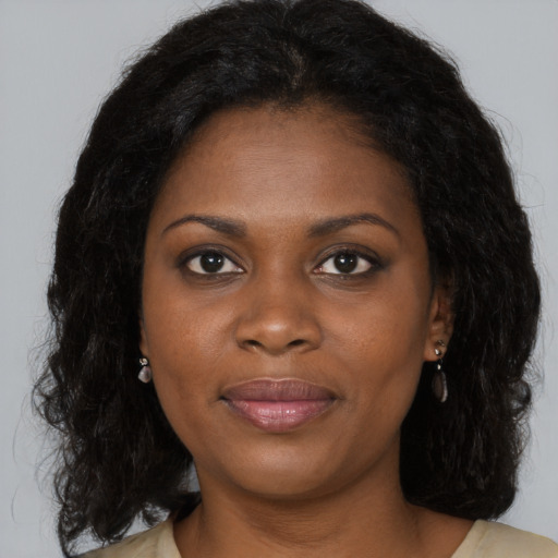 Joyful black young-adult female with long  brown hair and brown eyes