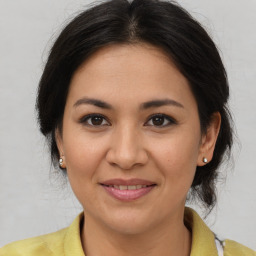 Joyful latino adult female with medium  brown hair and brown eyes