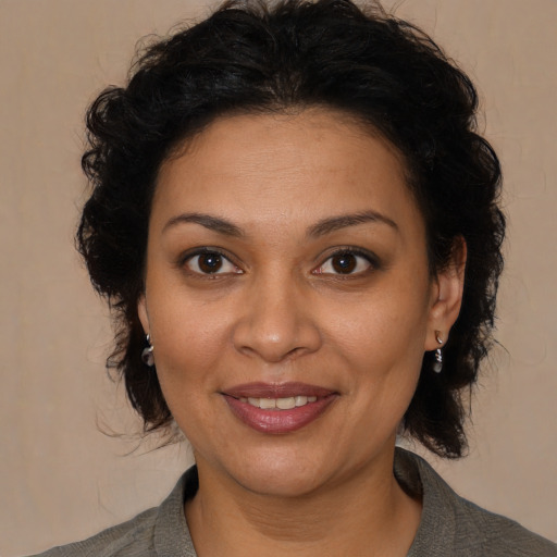 Joyful latino adult female with medium  brown hair and brown eyes