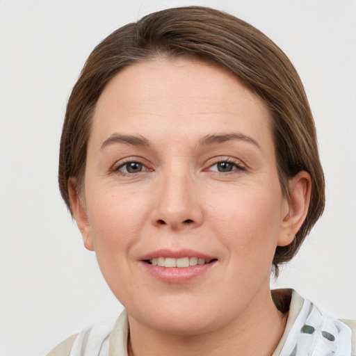 Joyful white young-adult female with medium  brown hair and grey eyes