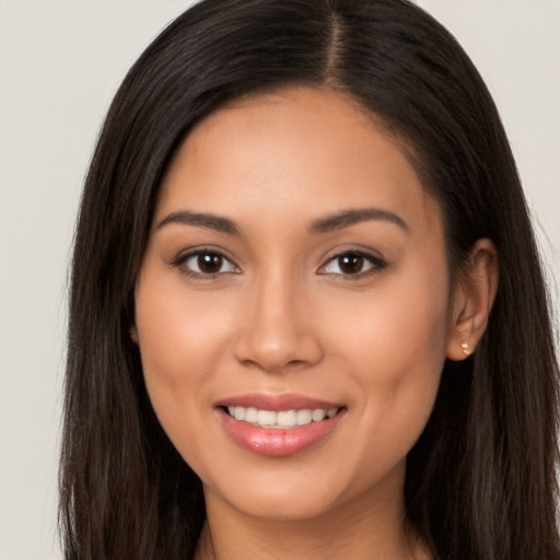 Joyful latino young-adult female with long  brown hair and brown eyes