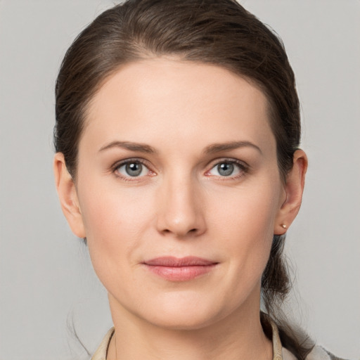 Joyful white young-adult female with medium  brown hair and grey eyes