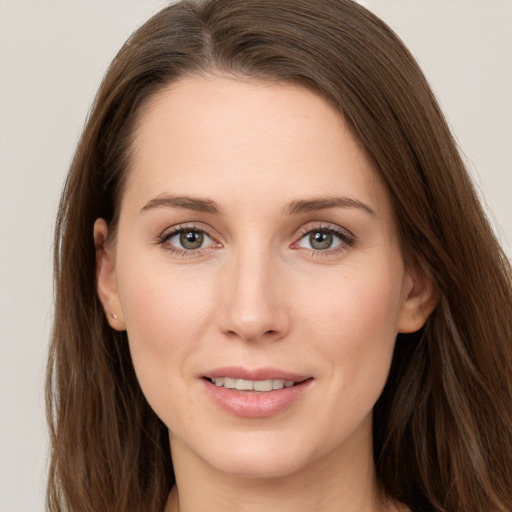 Joyful white young-adult female with long  brown hair and grey eyes