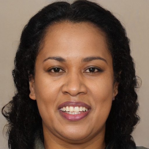 Joyful latino adult female with long  brown hair and brown eyes
