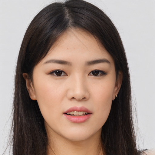 Joyful asian young-adult female with long  brown hair and brown eyes