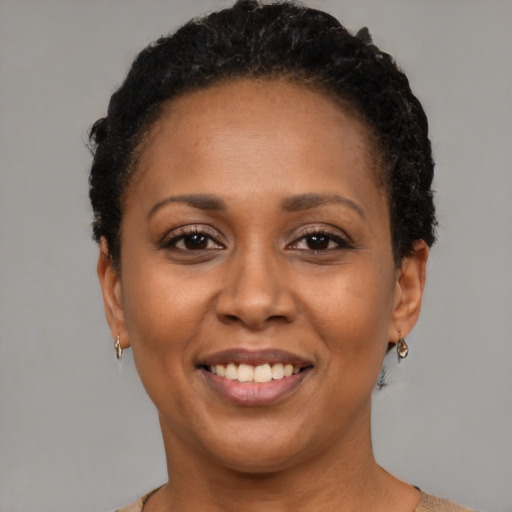 Joyful black adult female with short  black hair and brown eyes