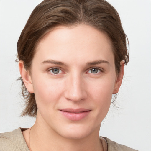 Joyful white young-adult female with medium  brown hair and grey eyes