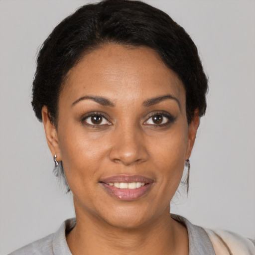 Joyful black adult female with short  black hair and brown eyes