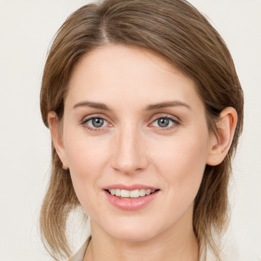 Joyful white young-adult female with medium  brown hair and grey eyes