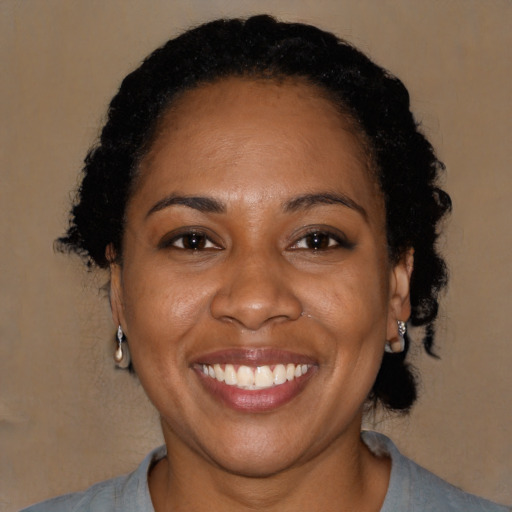 Joyful black adult female with short  black hair and brown eyes