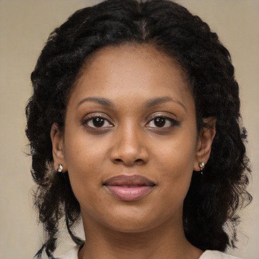 Joyful black young-adult female with long  brown hair and brown eyes