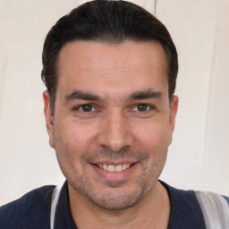 Joyful white adult male with short  black hair and brown eyes