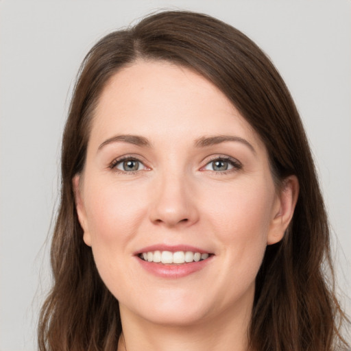 Joyful white young-adult female with long  brown hair and grey eyes