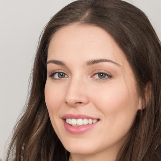 Joyful white young-adult female with long  brown hair and grey eyes