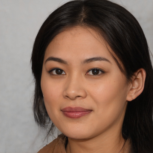 Joyful asian young-adult female with long  brown hair and brown eyes
