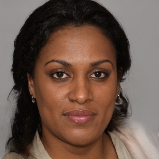 Joyful black adult female with medium  brown hair and brown eyes
