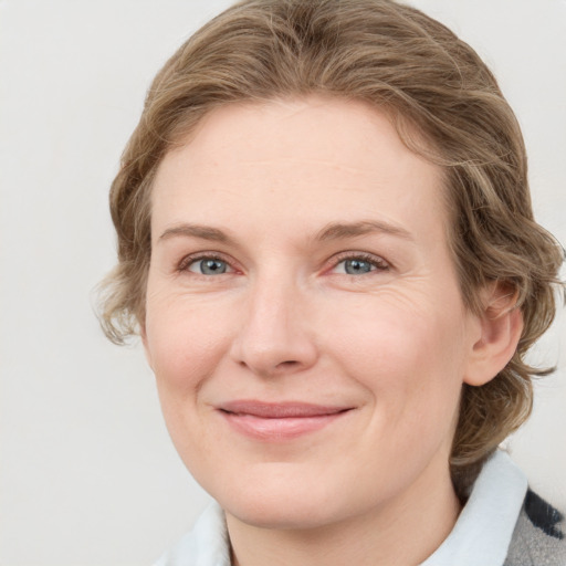 Joyful white young-adult female with medium  brown hair and blue eyes